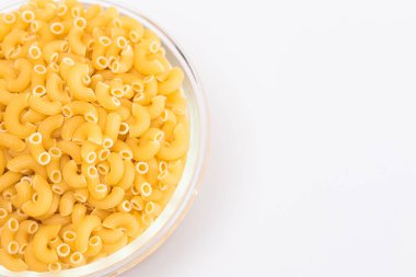 Beyaz Arkaplanda Cam Kavanoz 'da pişmemiş Chifferi Rigati Pasta. Şişman ve Sağlıksız Yemek. Klasik Kuru Makarna. İtalyan Kültür ve Mutfağı. Çiğ Makarna