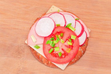 Domatesli çıtır krakerli sandviç, sosis, peynir, yeşil soğan ve turp. Kolay Kahvaltı 'da. Hızlı ve sağlıklı sandviçler. Lezzetli dolgulu kızarmış ekmek. Sağlıklı Beslenme Atıştırması