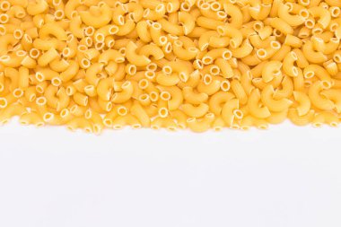 Pişmemiş Chifferi Rigati Pasta Beyaz Masa 'ya serpildi. Şişman ve Sağlıksız Yemek. Klasik Kuru Makarna. İtalyan Kültür ve Mutfağı. Çiğ Makarna