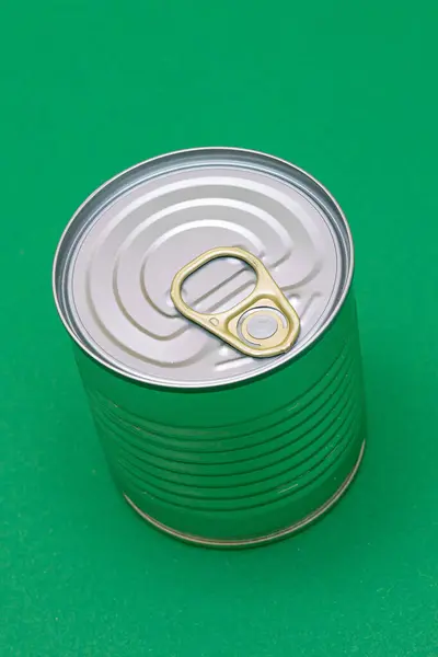Unopened Tin Can with Blank Edge on Green Background. Canned Food. Aluminum Can for Safe and Long Term Storage of Food. Steel Sealed Food Storage Container