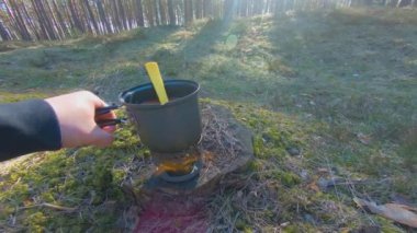 Camp Food. Cooking in a Hike Using a Small Cook Set - First Person View, Wide Angle. Food on the Trip. Traveler in a Spring Forest. Tourist in a Travel is Heating Food - POV Shot.