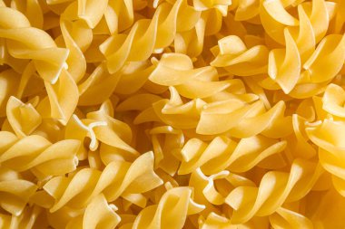 Pişmemiş Fusilli Makarna: Bir Spiral Makarna Mutfağı, Gurme Yemekleri İçin Canlı ve Dokulu Bir Arkaplan Oluşturma. Kuru makarna. Raw Macaroni - Top View, Düz Yat