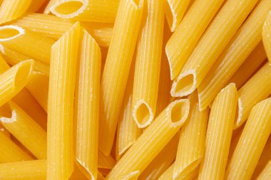 Pişmemiş Penne Rigate Makarnası: Gurme Aşçılık İçin Canlı ve Dokulu Bir Arkaplan Oluşturan Penne Makarna Mutfağı. Kuru makarna. Raw Macaroni - Top View, Düz Yat