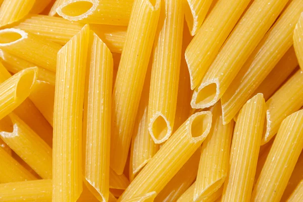 Pişmemiş Penne Rigate Makarnası: Gurme Aşçılık İçin Canlı ve Dokulu Bir Arkaplan Oluşturan Penne Makarna Mutfağı. Kuru makarna. Raw Macaroni - Top View, Düz Yat