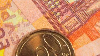 50 Euro 'luk banknotlara 20 Euro Cent madeni parası - Top View, Macro. Euro Para Birimi. Turuncu Kağıt Para. Bir sürü 20 Euro 'luk banknot. İş, Finans, Para ve Tasarruf Konsepti - Dönüşüm Sola