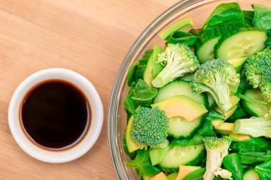 Taze yeşil Avocado Salatası, Brokoli, Ispanak ve Salatalık Detoks İçin Tahta Kesme Kurulunda Soya Sosu. Vejetaryen salatası. Vejetaryen Kültürü. Çiğ yemek. Sağlıklı beslenme ve sebze diyeti