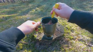Camp Food. Cooking in a Hike Using a Small Cook Set - First Person View, Wide Angle. Food on the Trip. Traveler in a Spring Forest. Tourist in a Travel is Heating Food - POV Shot.