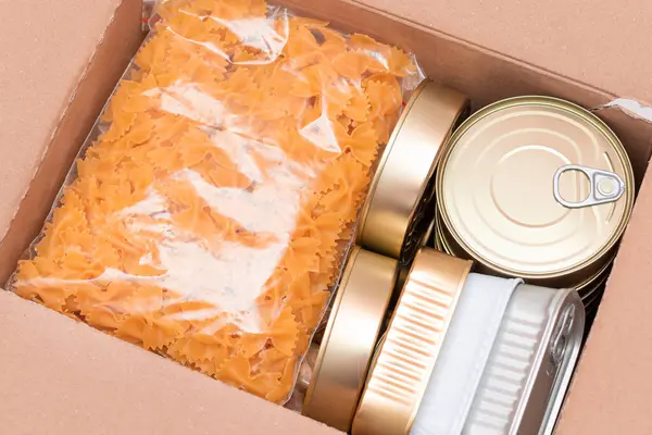 Food Reserves or Donation Box: Carton Box with Canned Food, Cereals and Grocery. Emergency Food Storage in Case of Crisis. Free Social Help, Blessings and Care. Strategic Food Supplies