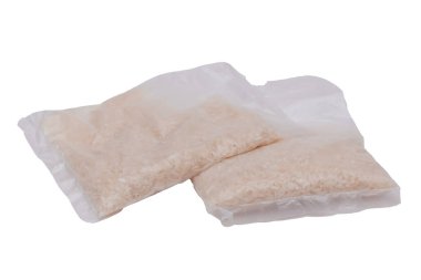 Beyaz arka planda izole edilmiş uzun pirinç taneli plastik torbalar. Kuru Pirinç içeren küçük şeffaf paketler - izolasyon