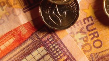 50 Euro 'luk banknotlara 20 Euro Cent madeni parası - Top View, Macro. Euro Para Birimi. Turuncu Kağıt Para. Bir sürü 20 Euro 'luk banknot. Ekonomi, Nakit ve Para Tasarruf Konsepti - Yavaş Dönüşüm Sağı