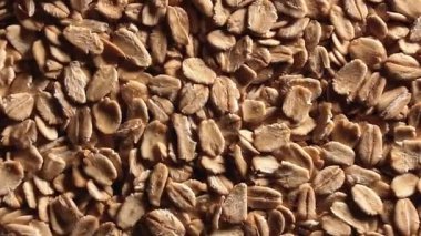 Yulaf Gevreği Arkaplanı Yavaşça Saat Yönünün Tersine Döner - Üst Görünüm, Alçak Anahtar Işığı. Dağıtılmış Kuru Yulaf Gevreği. Sağlıklı Kahvaltı ve Diyet Yiyici Malzemeleri - Açısal Döndürme Sola