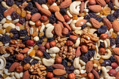 Karışık fındık, badem, ceviz, kaju, fıstık, fındık, kuru erik ve kuru üzüm. Farklı fındık karışımı. Çeşitli Fındık ve Kurutulmuş Meyvelerin Arkaplanı