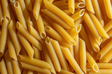 Pişmemiş Penne Rigate Makarnası: Gurme Aşçılık İçin Canlı ve Dokulu Bir Arkaplan Oluşturan Penne Makarna Mutfağı. Kuru makarna. Raw Macaroni - Top View, Düz Yat