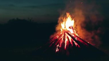 Blue Sky 'a karşı Yaz Gecesinde Büyük Yanan Kamp Ateşi. Ateşe odun. Uçan Kıvılcım. Seyahat ve Turizm Konsepti. Dev Alevli Şenlik Ateşi - Statik Çekim, Zaman Kaynağı