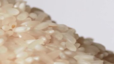 Kuru pişmemiş beyaz pirinç yığını dönüşümlü Macro. Çiğ Uzun Taneli Pirinç Yığını. Yakın plan. Asya mutfağı ve kültürü. Sağlıklı beslenme malzemeleri. Diyet Yemekler