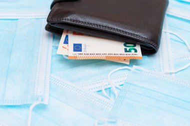 Black Mens Cüzdanı. Mavi Tek Kullanılabilir Tıbbi Yüz Maskeleri 'nin içinde Euro Para var. Tıbbi maske ticareti. Salgın ya da Salgın sırasında İş