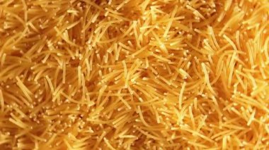 Saat Yönünün Tersinde Dönen Pişmemiş Eriştelerin Arkaplanı - Üst Görünüm, Yakın Çekim. Kuru Vermicelli Dönüşü dokusu. Low Key Light ile Çiğ Makarna - Sol Çevirme