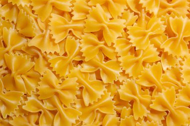 Pişmemiş Farfalle Makarnası: Gurme Aşçılık İçin Canlı ve Dokulu Bir Arkaplan Oluşturan Papyonlu Makarna Mutfağı. Kuru makarna. Raw Macaroni - Top View, Düz Yat