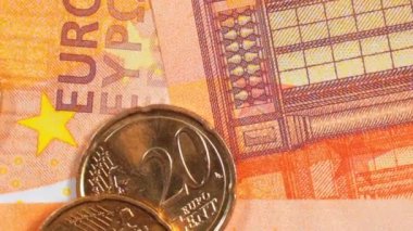 50 Euro 'luk banknotlara 20 Euro Cent madeni parası - Top View, Macro. Euro Para Birimi. Turuncu Kağıt Para. Bir sürü 20 Euro 'luk banknot. Ekonomi, Nakit ve Para Tasarruf Konsepti - Yavaş Dönüşüm Sola