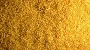 Saat Yönünde Yavaşça Dönen Pişmemiş Eriştelerin Arkaplanı - Üst Görünüm. Kuru Vermicelli Dönüşü dokusu. Low Key Light ile Çiğ Makarna - Sağ Döndürme