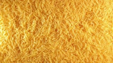 Background of Uncooked Golden Noodles that Rotating Clockwise - Top View. Texture of Dry Vermicelli Turning Around. Raw Pasta - Right Rotation