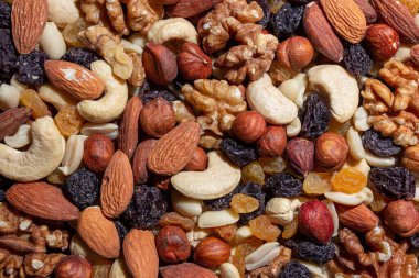 Karışık fındık, badem, ceviz, kaju, fıstık, fındık, kuru erik ve kuru üzüm. Farklı fındık karışımı. Çeşitli Fındık ve Kurutulmuş Meyvelerin Arkaplanı