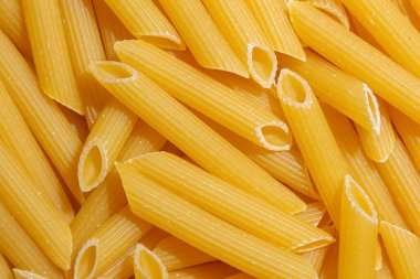 Pişmemiş Penne Rigate Makarnası: Gurme Aşçılık İçin Canlı ve Dokulu Bir Arkaplan Oluşturan Penne Makarna Mutfağı. Kuru makarna. Raw Macaroni - Top View, Düz Yat