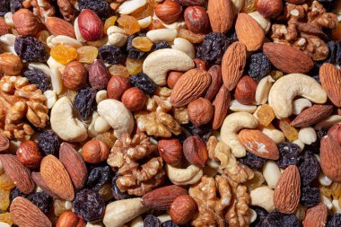 Karışık fındık, badem, ceviz, kaju, fıstık, fındık, kuru erik ve kuru üzüm. Farklı fındık karışımı. Çeşitli Fındık ve Kurutulmuş Meyvelerin Arkaplanı