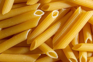 Pişmemiş Penne Rigate Makarnası: Gurme Aşçılık İçin Canlı ve Dokulu Bir Arkaplan Oluşturan Penne Makarna Mutfağı. Kuru makarna. Raw Macaroni - Top View, Düz Yat