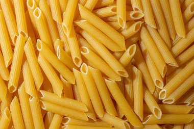 Pişmemiş Penne Rigate Makarnası: Gurme Aşçılık İçin Canlı ve Dokulu Bir Arkaplan Oluşturan Penne Makarna Mutfağı. Kuru makarna. Raw Macaroni - Top View, Düz Yat