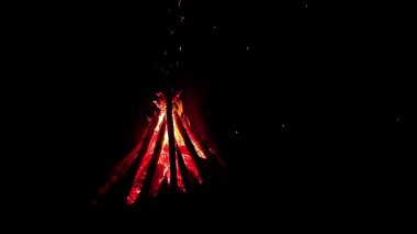 Burning Campfire - Isolated on Black. Wood on Fire. Flying Sparks. Travel and Tourism Concept. Big Flaming Bonfire at Summer Night - Static Shot, Slow Motion