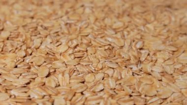 Uncooked Oat Flakes Rotating. Scattered Dry and Raw Oat Flakes. Healthy Breakfast and Diet Eating Ingredients