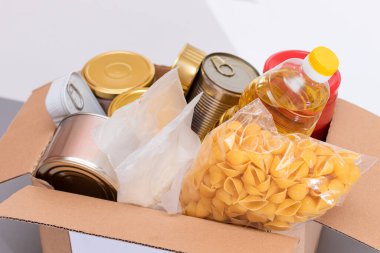 Bağış Kutusu Bedava Yemek. İçinde konserve yiyecek, mısır gevreği ve market olan bir karton kutu. Yemek rezervleri. Kriz anında acil durum gıda deposu. Ücretsiz Sosyal Yardım, Lütuf ve Bakım. Stratejik Gıda Malzemeleri