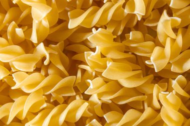 Pişmemiş Fusilli Makarna: Bir Spiral Makarna Mutfağı, Gurme Yemekleri İçin Canlı ve Dokulu Bir Arkaplan Oluşturma. Kuru makarna. Raw Macaroni - Top View, Düz Yat