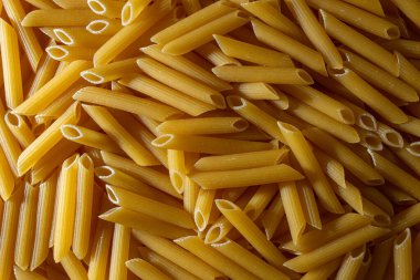 Pişmemiş Penne Rigate Makarnası: Gurme Aşçılık İçin Canlı ve Dokulu Bir Arkaplan Oluşturan Penne Makarna Mutfağı. Kuru makarna. Raw Macaroni - Top View, Düz Yat