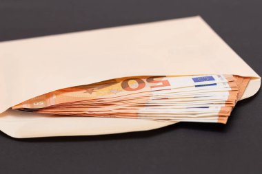 İçinde 50 Euro 'luk banknotlar olan bir Turuncu Kağıt Zarf. Nakit olarak maaş. Vergisiz sistem. Avrupa para birimi. Vergisiz ödemeler. Turuncu Kağıt Para. Bir sürü 50 Euro Fatura.