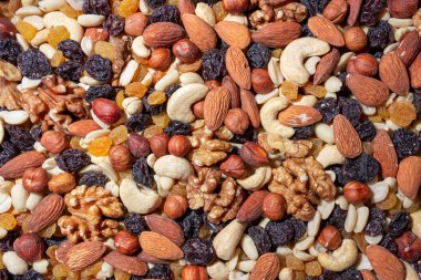 Karışık fındık, badem, ceviz, kaju, fıstık, fındık, kuru erik ve kuru üzüm. Farklı fındık karışımı. Çeşitli Fındık ve Kurutulmuş Meyvelerin Arkaplanı