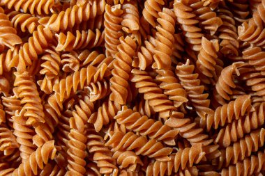 Pişmemiş Whole Grain Fusilli Makarna: Gurme Aşçılık İçin Canlı ve Dokulu Bir Arkaplan Oluşturan Tam Buğday Büfesi. Tam Tahıllı Kurutulmuş Makarna. Tam buğday hamurlu makarna.