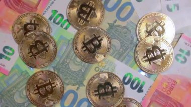 100 Euro 'luk banknotlarda Bitcoin Sikkeleri - Top View. Euro Para Nakiti ve Kripto Para Birimi. Yüz Euro 'luk banknot. Ekonomi, Borsa, Engelleme ve Elektronik Para Konsepti - Yavaş Çevirme Sola