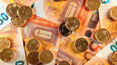 50 Euro 'luk banknotlara 20 Euro Cent madeni parası - Top View. Euro Para Birimi. Turuncu Kağıt Para. Bir sürü 20 Euro 'luk banknot. İş, Finans, Para ve Tasarruf Konsepti - Dönüşüm Sola