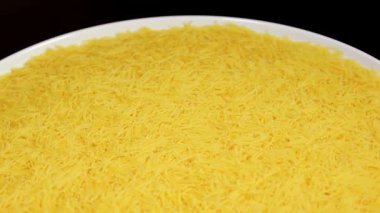 Raw Uncooked Noodles on White Plate Rotating against Black Background. Dry Vermicelli Turning Around. Raw Pasta