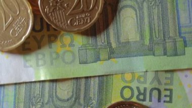 100 Euro 'luk banknotlara 20 Euro Cent madeni parası - Top View, Macro. Euro Para Birimi. Yeşil Kağıt Para. Yüz Euro 'luk banknot. İş, Finans, Para ve Tasarruf Konsepti - Yavaş Dönüşüm Sağı