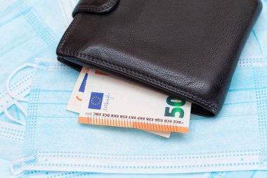 Black Mens Cüzdanı. Mavi Tek Kullanılabilir Tıbbi Yüz Maskeleri 'nin içinde Euro Para var. Tıbbi maske ticareti. Salgın ya da Salgın sırasında İş
