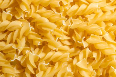 Pişmemiş Fusilli Makarna: Bir Spiral Makarna Mutfağı, Gurme Yemekleri İçin Canlı ve Dokulu Bir Arkaplan Oluşturma. Kuru makarna. Raw Macaroni - Top View, Düz Yat