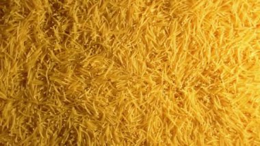 Saat Yönünün Tersinde Yavaşça Dönen Pişmemiş Eriştelerin Arkaplanı - Üst Görünüm. Kuru Vermicelli Dönüşü dokusu. Low Key Light ile Çiğ Makarna - Sol Çevirme