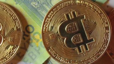 100 Euro 'luk banknotlarda Bitcoin Sikkeleri - Top View, Macro. Euro Para Nakiti ve Kripto Para Birimi. Yüz Euro 'luk banknot. Ekonomi, Borsa, Engelleme ve Elektronik Para Konsepti - Yavaş Çevirme Sola