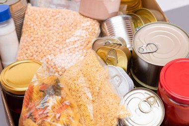 Bağış Kutusu Bedava Yemek. İçinde konserve yiyecek, mısır gevreği ve market olan bir karton kutu. Yemek rezervleri. Kriz anında acil durum gıda deposu. Ücretsiz Sosyal Yardım, Lütuf ve Bakım. Stratejik Gıda Malzemeleri