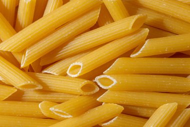 Pişmemiş Penne Rigate Makarnası: Gurme Aşçılık İçin Canlı ve Dokulu Bir Arkaplan Oluşturan Penne Makarna Mutfağı. Kuru makarna. Raw Macaroni - Top View, Düz Yat