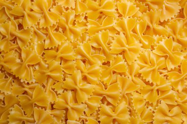 Pişmemiş Farfalle Makarnası: Gurme Aşçılık İçin Canlı ve Dokulu Bir Arkaplan Oluşturan Papyonlu Makarna Mutfağı. Kuru makarna. Raw Macaroni - Top View, Düz Yat