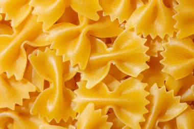 Pişmemiş Farfalle Makarnası: Gurme Aşçılık İçin Canlı ve Dokulu Bir Arkaplan Oluşturan Papyonlu Makarna Mutfağı. Kuru makarna. Raw Macaroni - Top View, Düz Yat